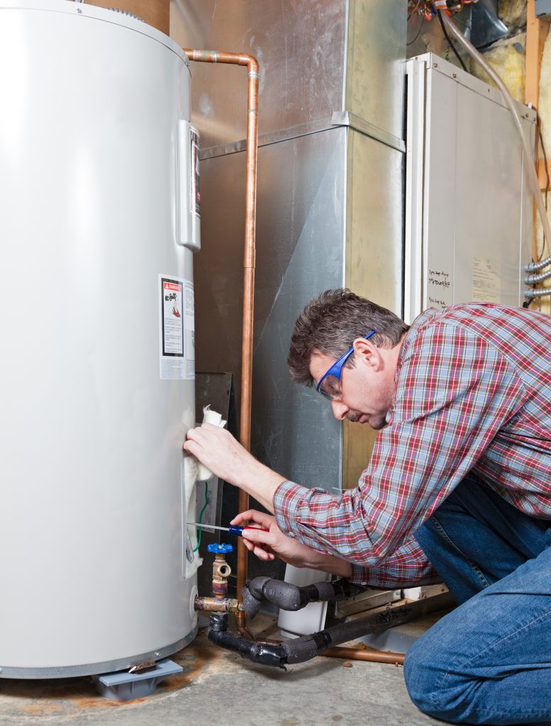 A plumber performing maintenance on a residential water heater